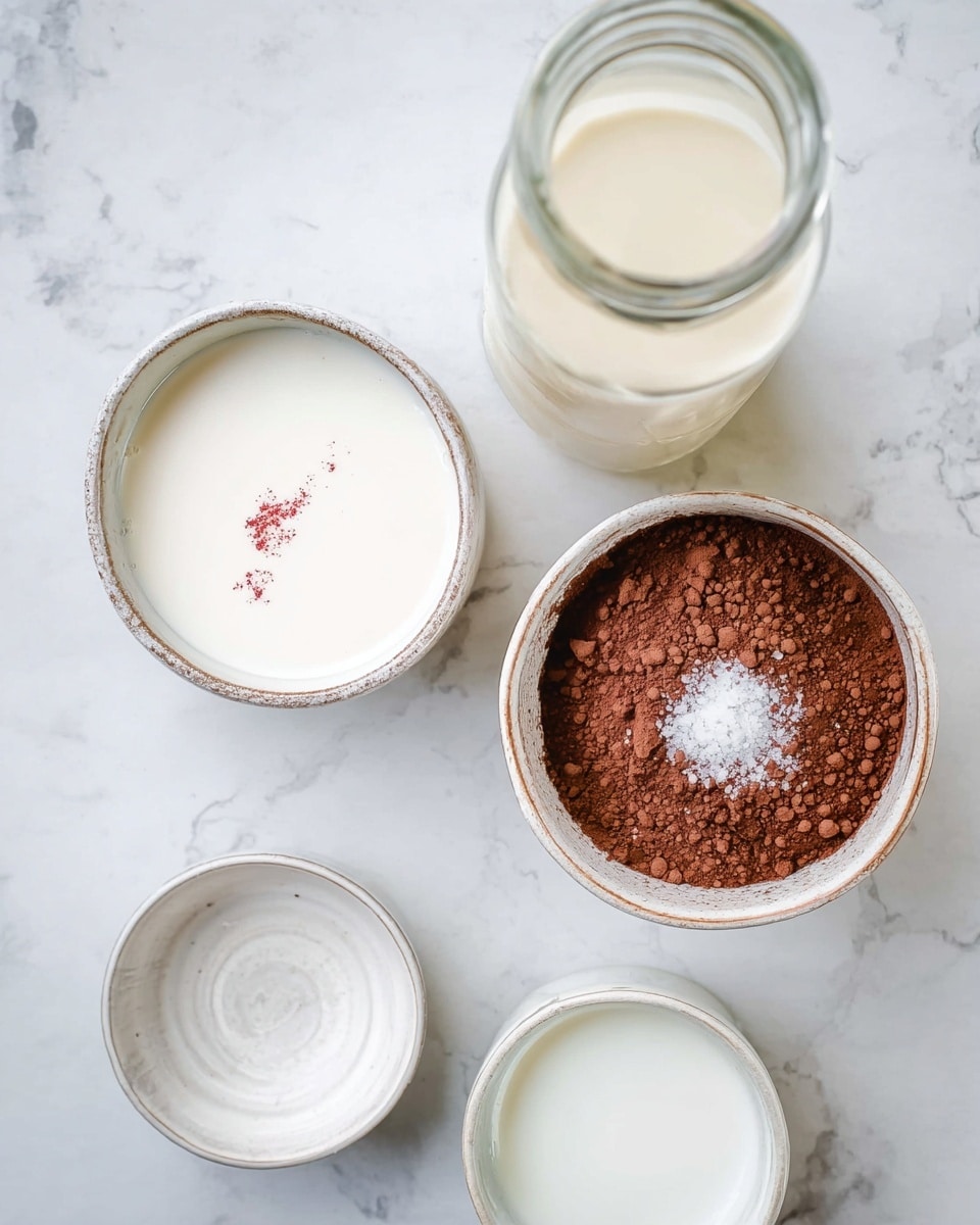 The image shows several small white bowls and a clear glass bottle arranged on a white marbled surface. Two bowls are filled with a creamy white liquid, one of which has a small red streak on top. A third bowl contains a pile of brown cocoa powder with a small amount of white salt sprinkled in the center. There are also two empty white bowls and a bottle with a pale liquid inside. The overall setup looks clean and organized, with a soft natural light illuminating the ingredients. Photo taken with an iphone --ar 4:5 --v 7