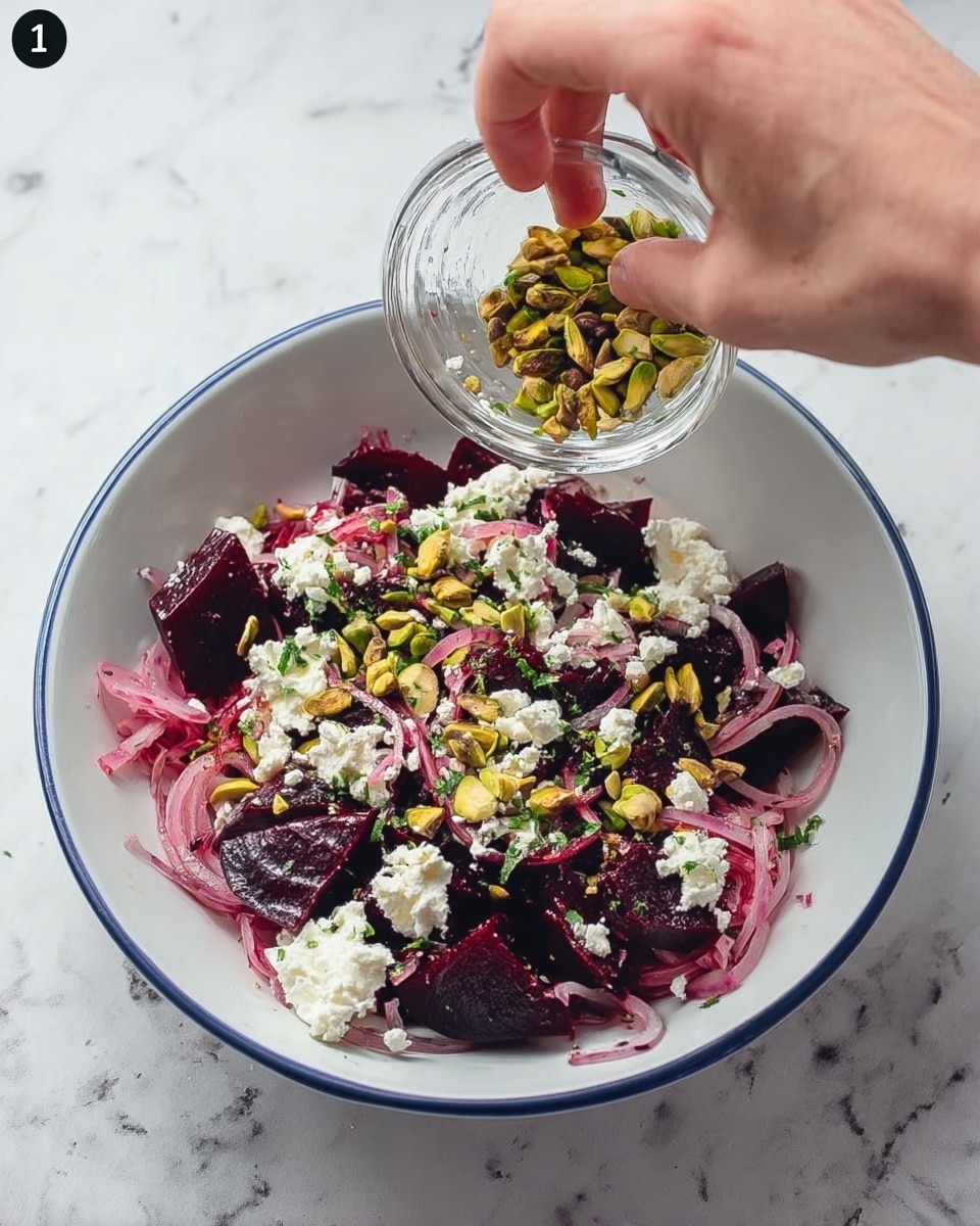 The dish is presented in a white bowl placed on a white marbled surface. It has multiple layers starting with dark red beetroot pieces at the bottom, topped with thin, pale pink slices of onion. Over this, there are green pistachio nuts scattered across, adding texture and contrast. The final top layer consists of crumbled white cheese sprinkled all over the dish, creating a vibrant mix of colors and textures. A woman’s hand is shown squeezing lemon juice into a clear glass bowl with the ingredients inside, and then mixing everything together. Photo taken with an iphone --ar 4:5 --v 7