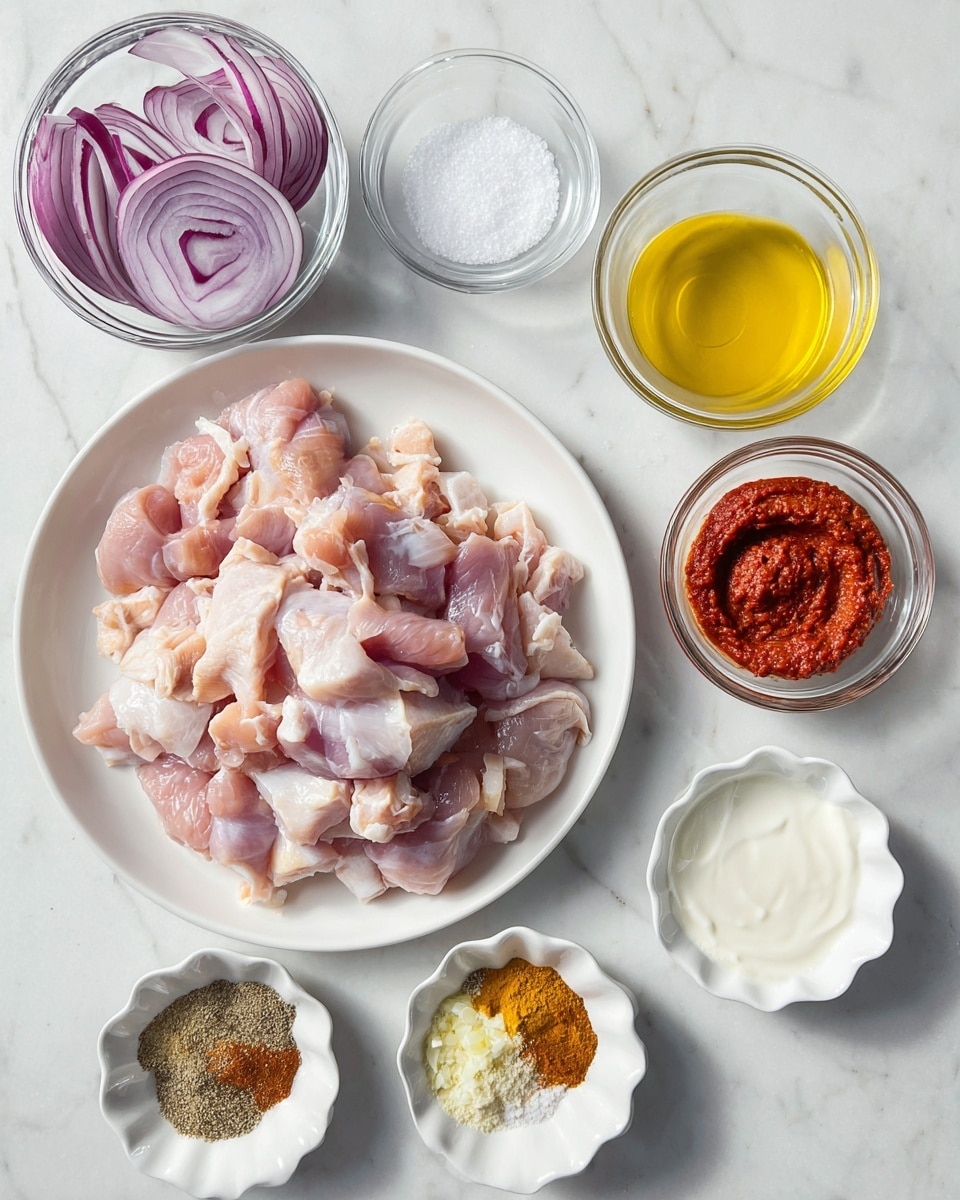 A white plate in the center is filled with raw light pink chicken pieces showing some white fat. Above the plate on the right side are two small clear glass bowls, one with coarse white salt and the other a swirl of thick bright red paste in a white scalloped bowl. On the left side near the top, a clear glass bowl holds large pieces of purple and white sliced red onion. Below the main plate, there are five small white scalloped bowls and one small white plain bowl arranged in an arc. These bowls contain different ingredients: a heap of mixed ground spices in shades of brown and yellow, bright yellow oil, thick white yogurt, minced garlic, and small bits of another light-colored paste. All items are placed on a white marbled surface. photo taken with an iphone --ar 4:5 --v 7