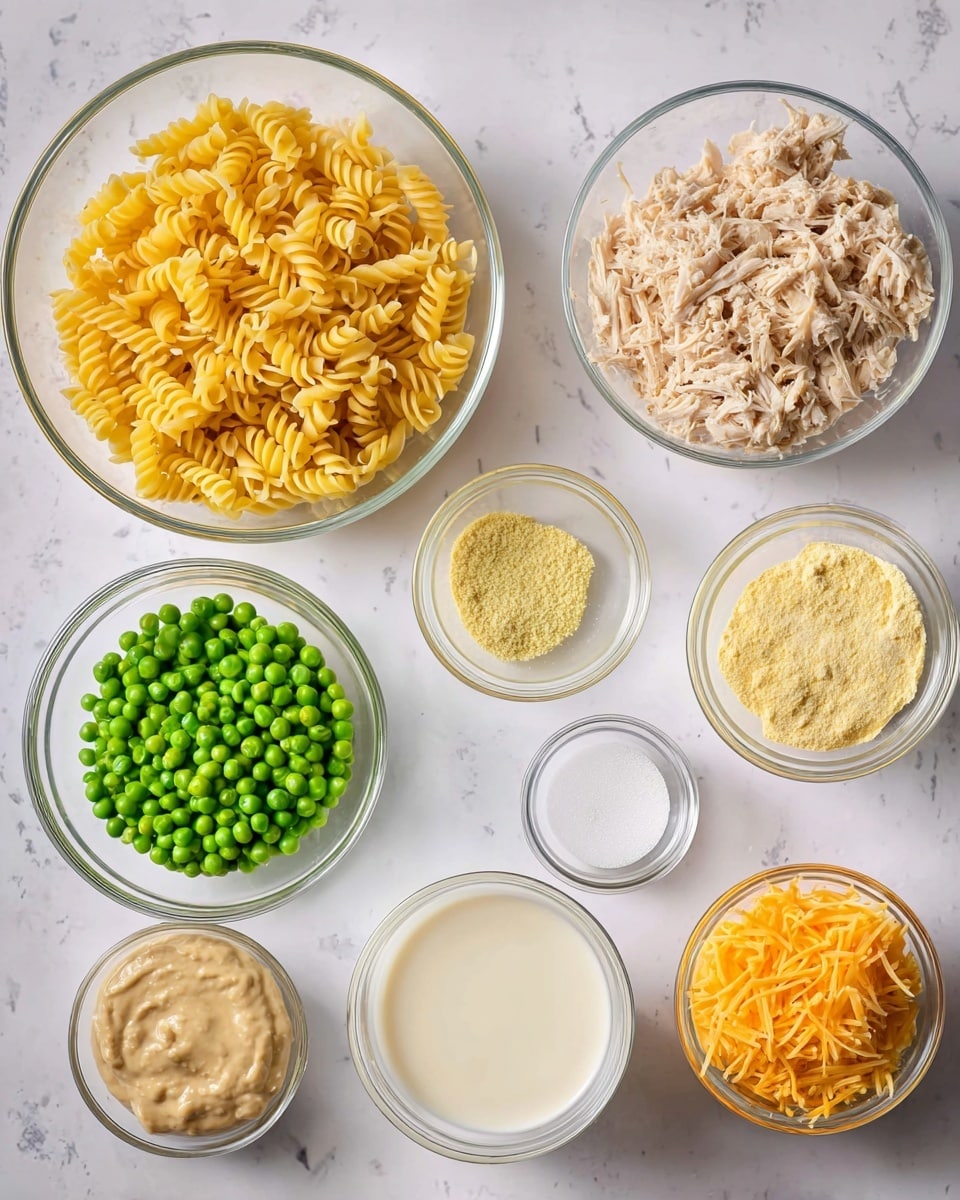 The image shows nine clear glass bowls arranged on a white marbled surface, each filled with different ingredients. Starting from the top left, there is a large bowl filled with dry, yellow spiral pasta. To its right, a medium glass bowl contains shredded, light brown cooked chicken. On the far right side, three small glass bowls are lined up vertically: the top bowl has a light yellow powder, the middle bowl holds a pale yellow liquid, and the bottom bowl contains a white salt-like substance. Below the chicken, toward the center, a medium-sized glass bowl is filled with bright green frozen peas. To the left of the peas is a small glass bowl with a creamy, beige mixture. Standing right next to the peas on the right is a small bowl with shredded orange cheese. Finally, at the bottom right of the image, a medium bowl holds white milk. Photo taken with an iphone --ar 4:5 --v 7