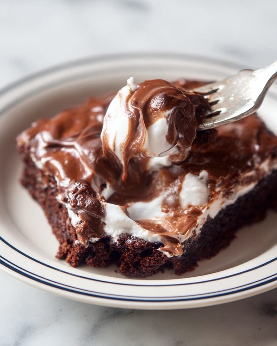 A white plate with a thin navy blue rim holds a piece of chocolate dessert that has a soft, dark brown cake layer at the bottom, topped with a thick, shiny milk chocolate layer mixed with slightly melted white cream or marshmallow, giving it a swirled texture. A fork lifts a bite-sized piece of the dessert, showing the moist and rich dark brown cake layer inside, with the glossy chocolate and cream mix coating the outside. The background is a white marbled surface. Photo taken with an iphone --ar 4:5 --v 7