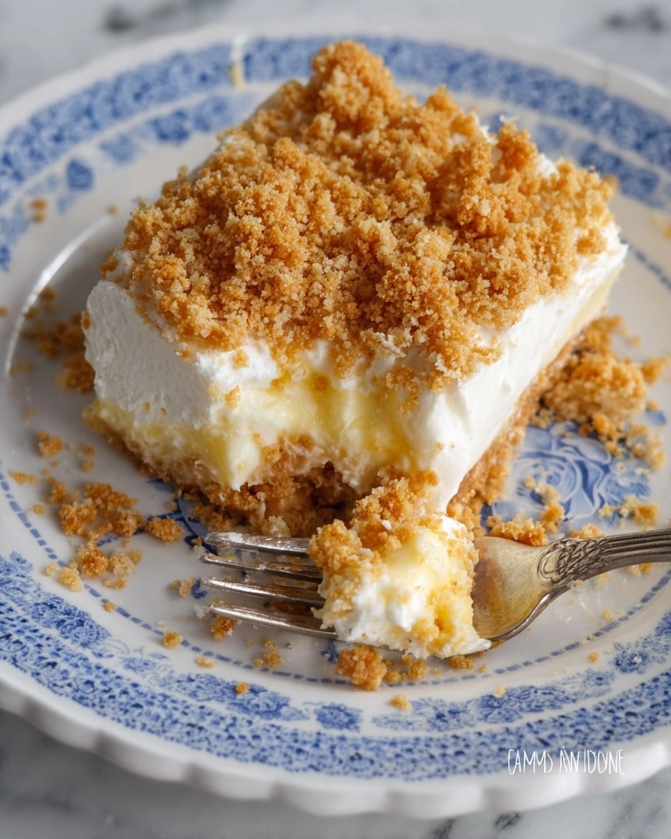 A close-up image shows a creamy dessert on a white plate with blue patterns around the edge. The dessert has two visible layers: a thick white creamy layer on the bottom and a crumbly golden brown topping covering the top. Some crumbs have fallen onto the plate around the dessert. A silver fork, holding a bite-sized piece of the dessert with both layers and crumbs sticking to it, rests near the plate. The surface underneath the plate is a white marbled texture. photo taken with an iphone --ar 4:5 --v 7