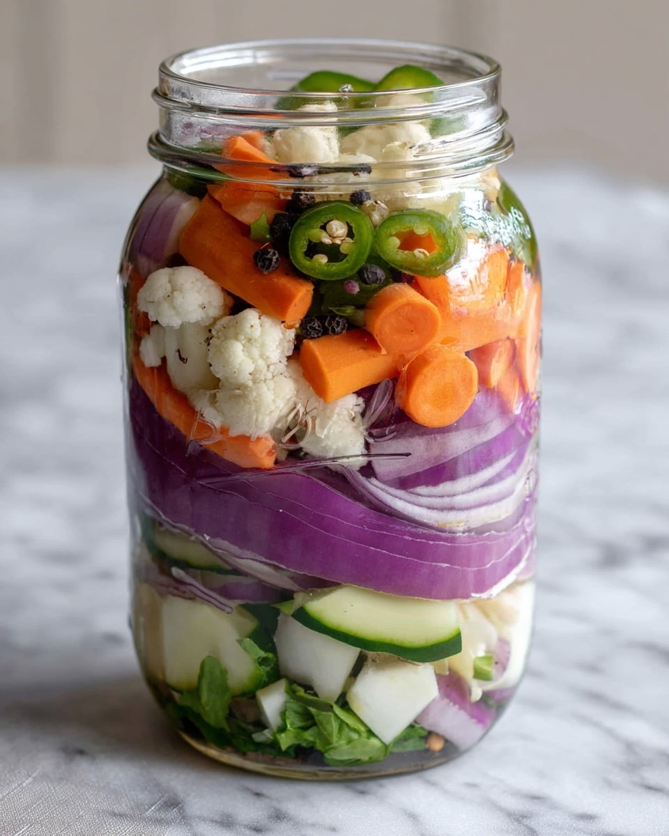 A clear glass jar filled with colorful layers of fresh vegetables stands on a soft, white marbled surface. Starting from the bottom, there are thick purple onion slices mixed with green jalapeño rings. Moving upward, the layers alternate between bright orange carrot slices, small white cauliflower florets, and pale green cucumber slices. Interspersed throughout the jar are black peppercorns and a few green leaves, creating a fresh look. The vegetables are tightly packed and vibrant, with each layer visible through the clear jar. photo taken with an iphone --ar 4:5 --v 7