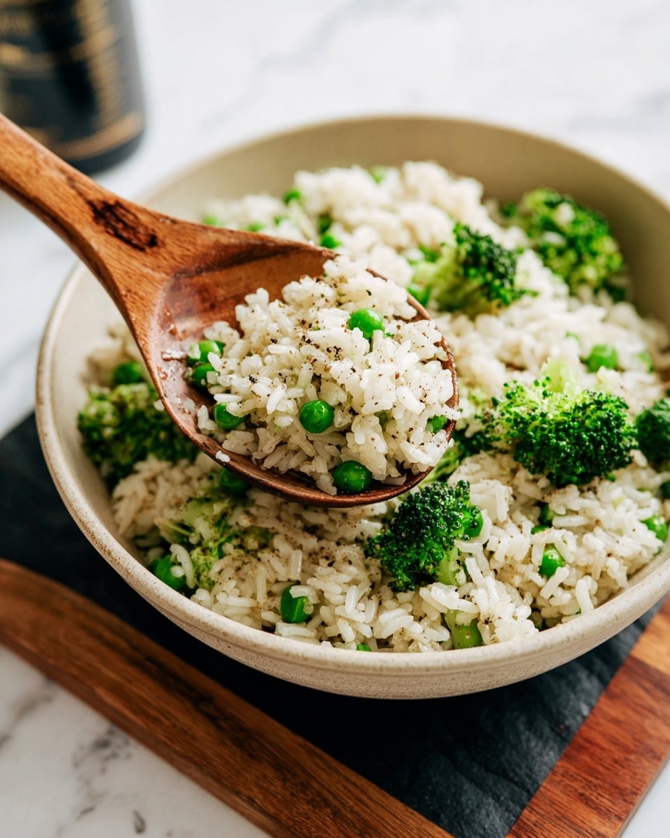 The image shows a light beige bowl filled with cooked white rice mixed with small broccoli florets and green peas. The rice is speckled with black pepper, giving a subtle contrast to the white grains. A wooden spoon holds a scoop of this rice mixture, highlighting the bright green broccoli and peas mixed in with the fluffy white rice. The bowl is set on a black board with a wooden edge, and the background is a white marbled texture. Photo taken with an iphone --ar 4:5 --v 7