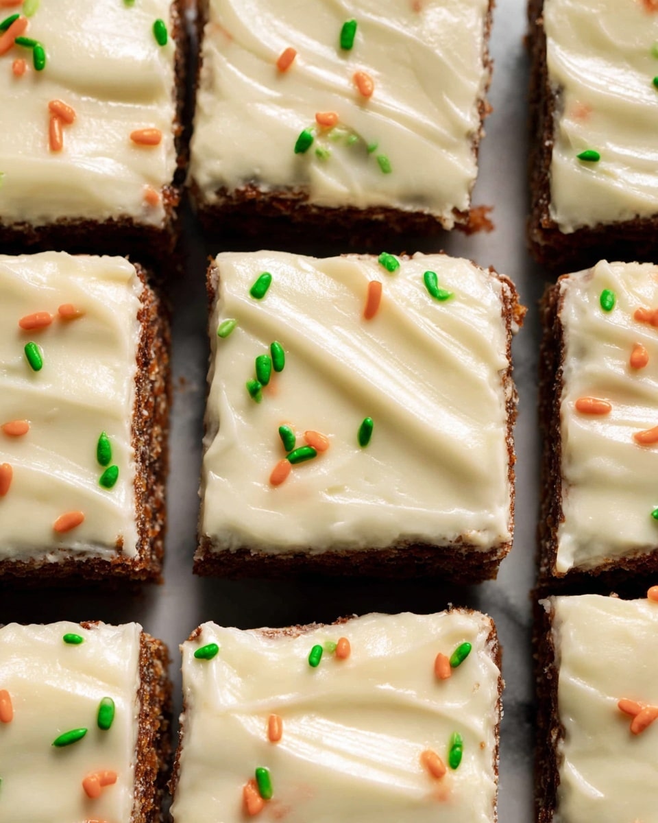 This image shows a close-up of a carrot cake cut into squares, arranged in rows on a white marbled surface. Each piece has two visible layers: a dark brown cake base with a rough, moist texture, and a thick layer of smooth, creamy off-white frosting spread evenly on top. The frosting has light swirls and is decorated with small orange and green sprinkles scattered across the surface. The pieces are neatly cut with clean edges, and the light highlights the glossy finish of the frosting. Photo taken with an iphone --ar 4:5 --v 7