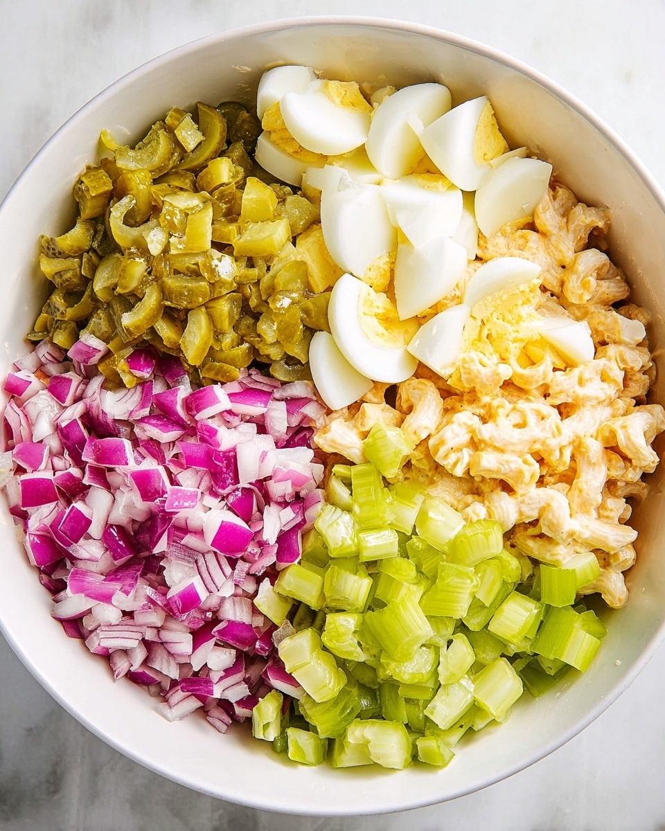 In a white bowl resting on a white marbled surface, there are five distinct layers of ingredients arranged side by side before mixing. Starting from the top, there are quartered hard-boiled eggs showing their smooth white edges and pale yellow centers. To the right, there are chopped green pickles with a slightly glossy texture. Below the pickles, bright and fresh diced celery pieces with a crisp look form the next layer. On the bottom left, vibrant chopped red onions with purple and white colors create contrast, and beneath all these layers, you can glimpse creamy macaroni salad with a light orange dressing. photo taken with an iphone --ar 4:5 --v 7
