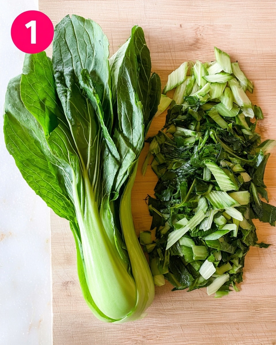 The image shows a fresh green bok choy placed to the left on a light wooden surface. To the right of the whole bok choy, there is a pile of chopped bok choy leaves and stems, showing different shades of green from dark leafy parts to lighter thick stems. The texture looks crisp and fresh, with a natural shine on the green leaves and stems. There is a small round pink label with the number one in white at the top left corner. The background is a white marbled texture. photo taken with an iphone --ar 4:5 --v 7