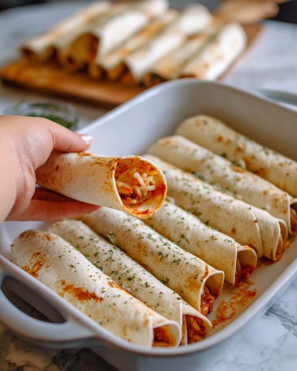 A woman's hand is holding one rolled taco filled with a red-orange sauce and shredded cheese inside. There are eight more rolled tacos lined up next to each other in a large white dish sprinkled with dried herbs, showing a smooth and soft-looking white tortilla shell with some spots of sauce slightly escaping from the ends. In the background, there is another white dish filled with more rolled tacos, all placed on a white marbled surface. Photo taken with an iphone --ar 4:5 --v 7