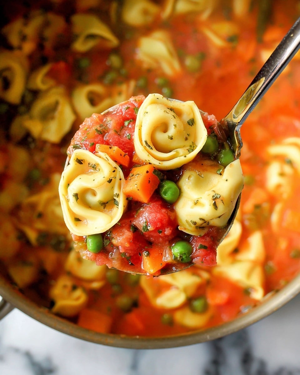 A ladle filled with three layers of food is held above a pot: the base layer is a clear red tomato sauce with small bits of herbs, followed by a middle layer of vibrant diced orange and red vegetables mixed with bright green peas, and the top layer features pale yellow tortellini pasta with a smooth texture, folded and slightly shiny, with the same diced vegetables and peas resting on and around the pasta; the background shows more tortellini and sauce in a pot, all on a white marbled surface photo taken with an iphone --ar 4:5 --v 7