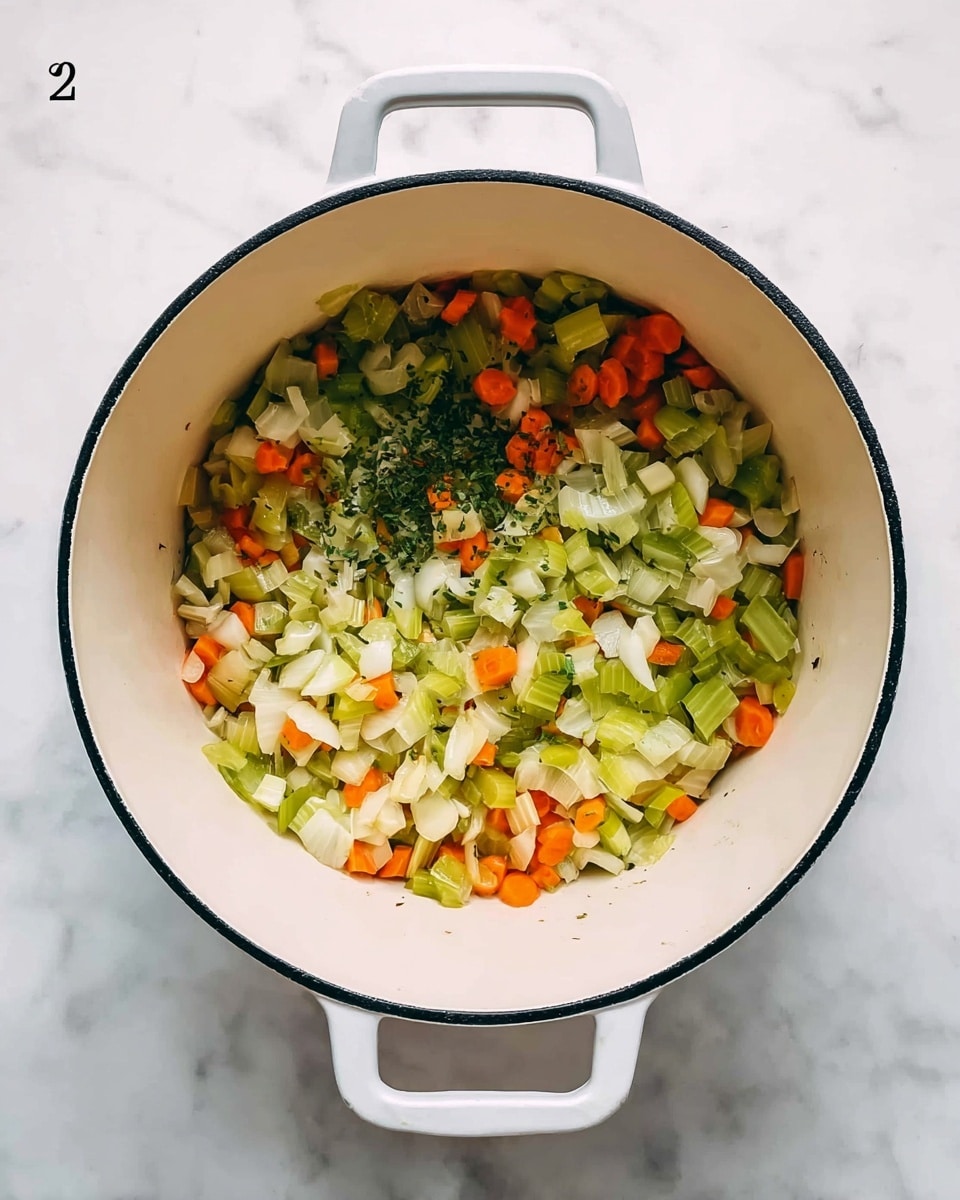 A top view of a white pot with black rim filled with chopped vegetables including light green celery, white onions, and orange carrots mixed with herbs, sitting on a white marbled surface photo taken with an iphone --ar 4:5 --v 7