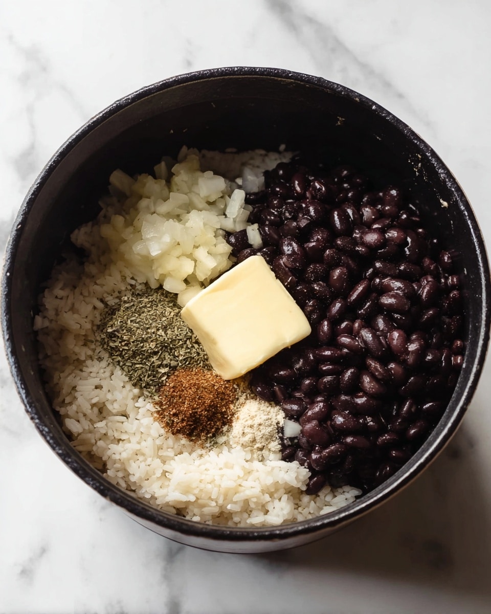 A black pot sits on a white marbled surface, filled with separate layers of ingredients. The bottom layer is white rice spread across the pot's base and sides. On top and to one side, dark shiny black beans cover about half the visible surface. To the left, there are small white chopped onions. Near the center, a square piece of pale yellow butter rests on the rice. Around the butter, there are small piles of different spices: a brown powder, a coarse salt, a mix of dried herbs, and finely minced garlic. All ingredients are loose and unmixed, showing clear texture differences. photo taken with an iphone --ar 4:5 --v 7