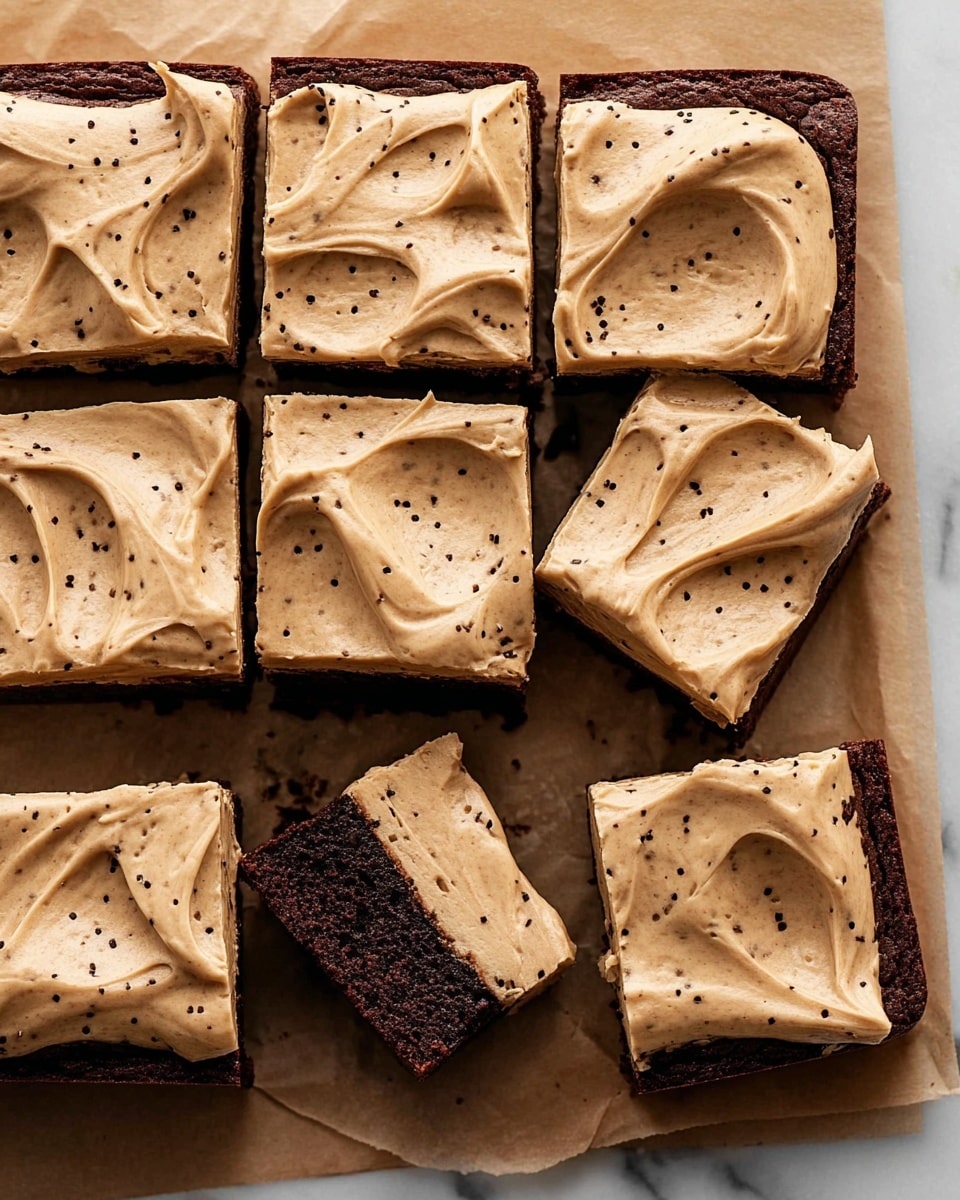 The image shows a square chocolate brownie cut into 12 even pieces, arranged on light brown parchment paper over a white marbled surface. Each brownie piece has one thick layer with a rich brown color and a smooth, creamy beige frosting spread on top, dotted with small dark flecks. The frosting is swirled in a decorative way, giving a textured look with some peaks and valleys. One piece at the bottom left is missing a bite showing the moist inside. Photo taken with an iphone --ar 4:5 --v 7