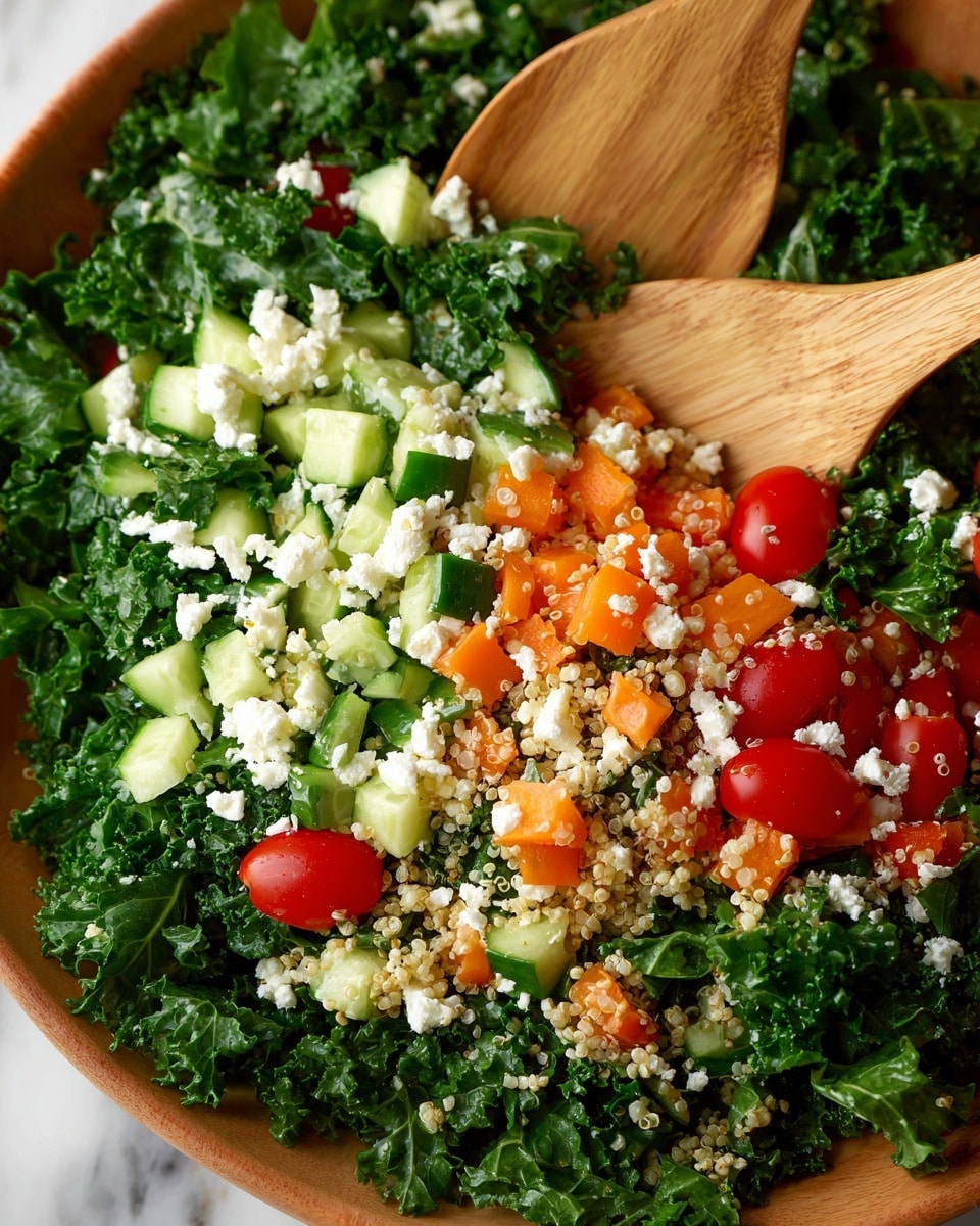A close-up view of a fresh salad in a white bowl showing four main layers: the first layer is dark green, curly kale leaves with a rough texture; the second layer is small orange bell pepper cubes scattered throughout; the third layer consists of diced light green cucumber pieces with smooth skin; the fourth layer is a mix of white crumbly cheese and light beige quinoa grains sprinkled over the top. Several red cherry tomato halves are placed on the salad, adding bright color. Two wooden salad spoons are partially visible, one standing upright and the other laying flat within the salad. The bowl is placed on a white marbled surface. Photo taken with an iphone --ar 4:5 --v 7